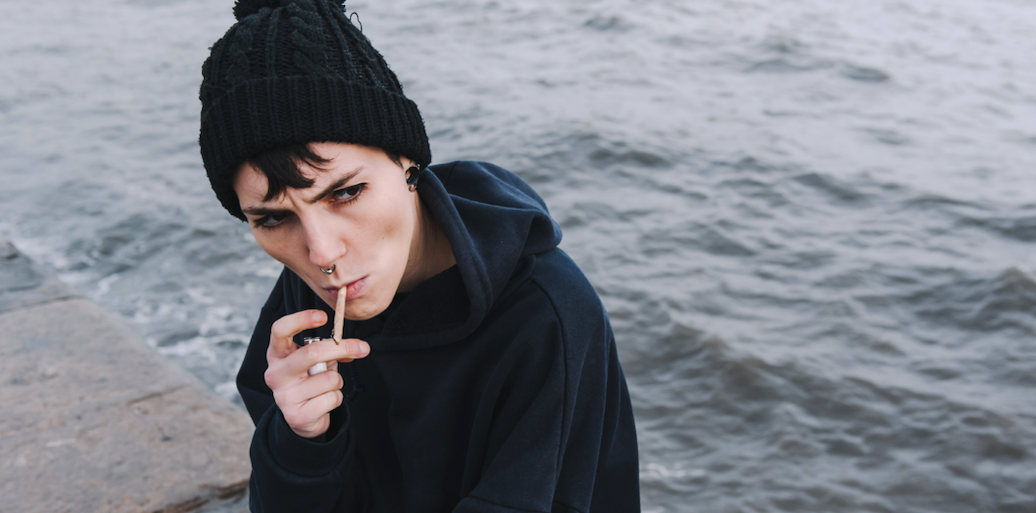 girl holding the smoke of her joint