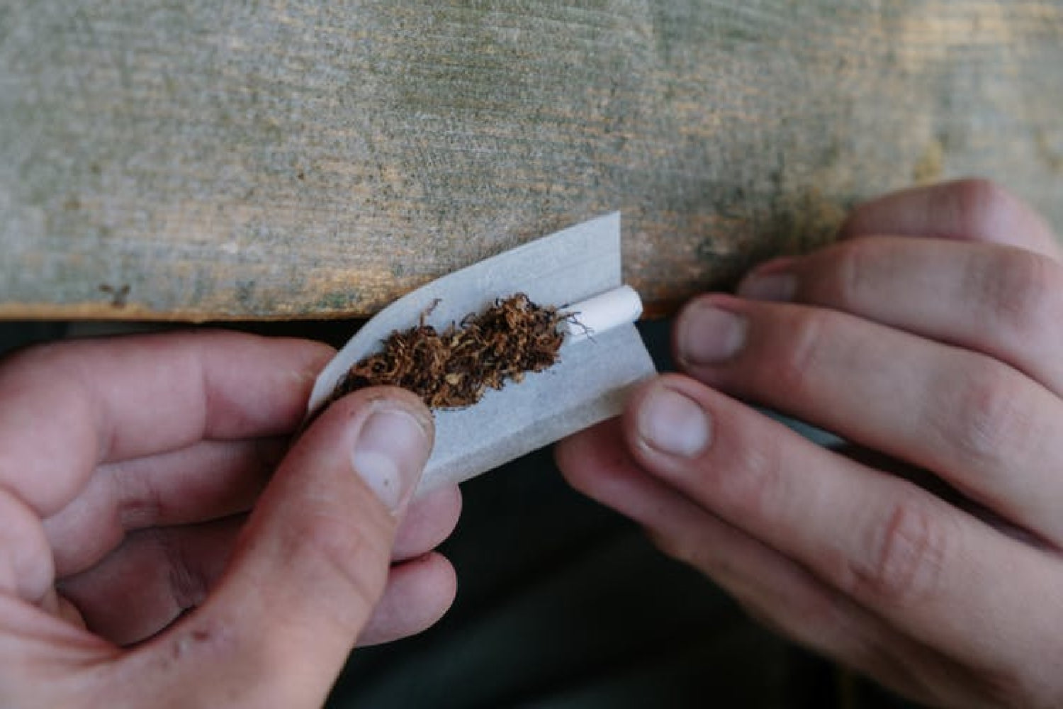 Hands rolling an european joint
