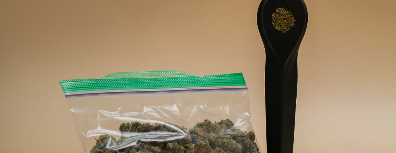 plastic bag with cannabis and a black smoking pipe