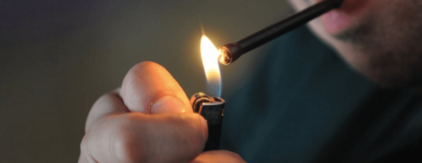 man burning a one hitter