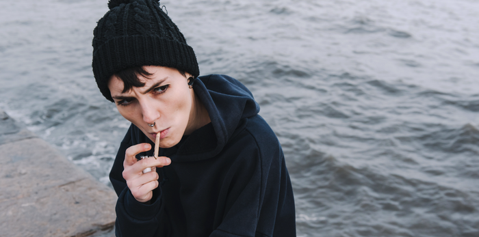 girl holding the smoke of her joint