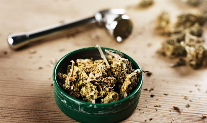 Bowl of cannabis nugs next to a weed pipe