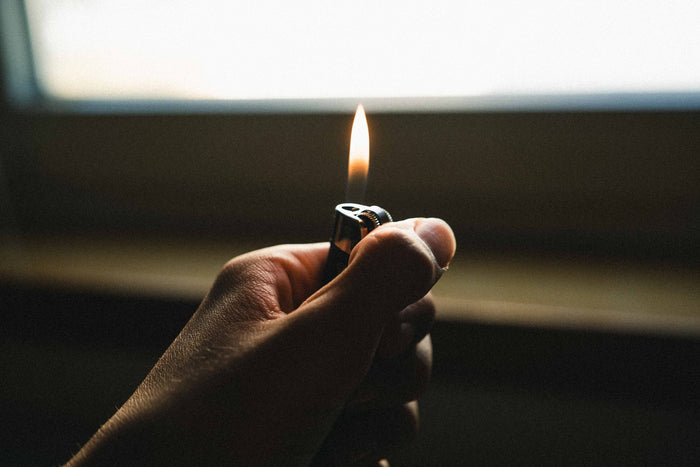 Hand holding a lit clipper lighter