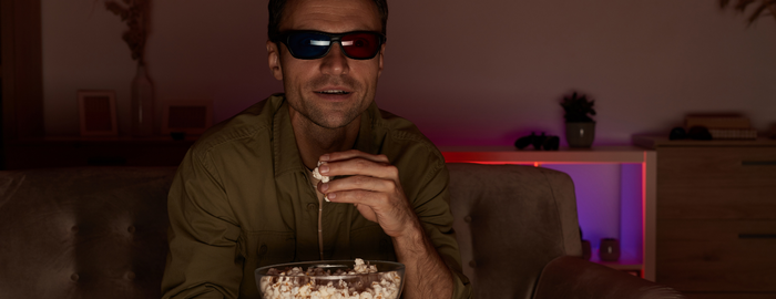 high man watching movies and eating popcorn