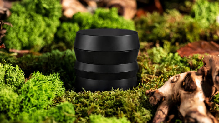 A weed grinder sits on the forest floor