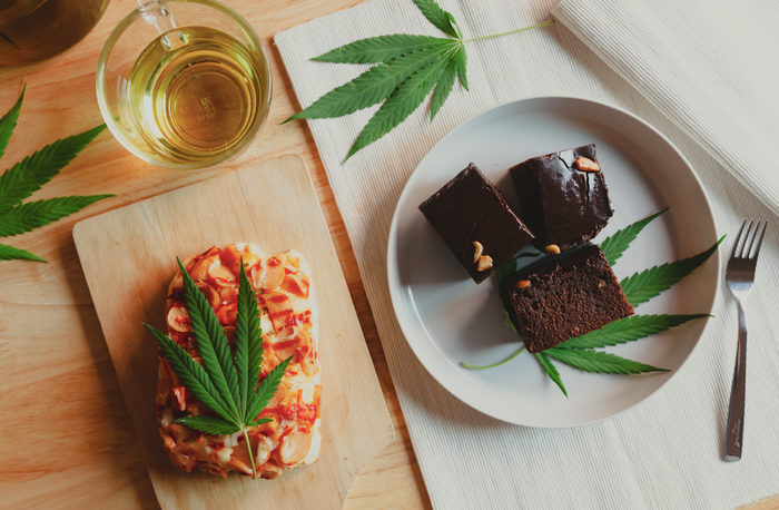 essbare Brownies, Pizza und Cannabis-Tee auf einem Tisch