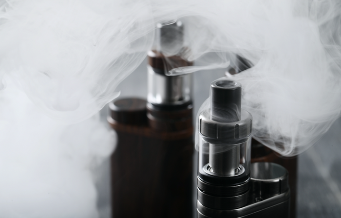 deux vaporisateurs d'herbe noirs avec de la fumée