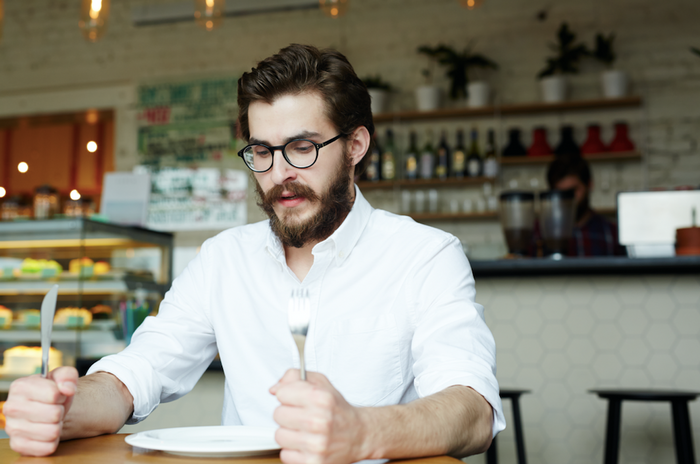 Hungry man with empty plate at a restaurant