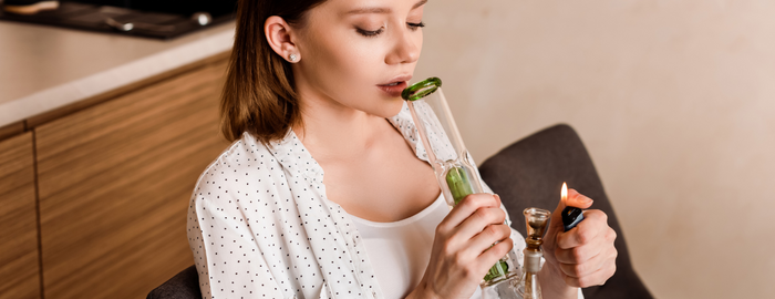 woman inhaling from a gravity bong