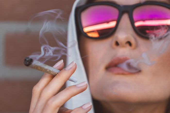 A woman inhales cannabis properly from a joint