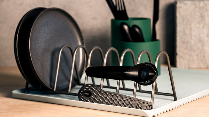 A clean black weed pipe sits on a dish rack drying. 