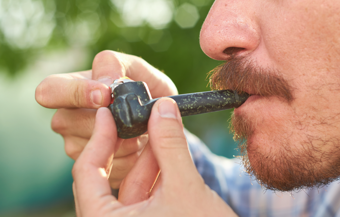 Man smoking from a pipe with carb hole