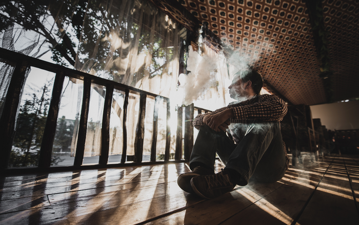 man sitting on the floor vaping