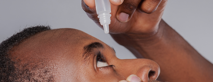 man using eye drops