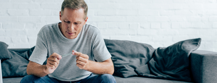man on a sofa with a rolled joint in hand