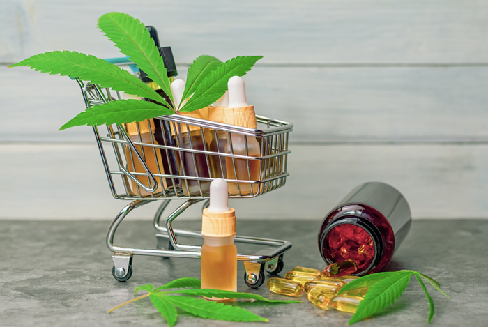 shopping cart with CBD oil and cannabis pills and plants