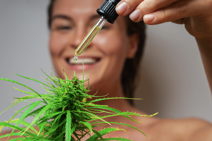 Woman with THCa oil concentrate with cannabis plant