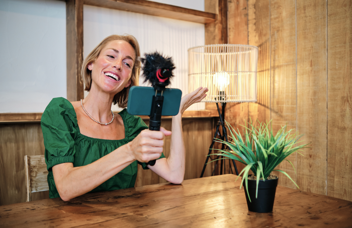 Woman cannabis influencer recording herself with her cellphone and mic