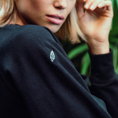 Woman with black sweatshirt with HOJ leaf icon on sleve